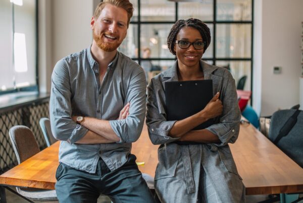 Man en vrouw zitten op tafel lachend naar de camera